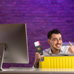 front view office worker sitting his working place with tickets passport bag