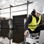 full shot engineer with laptop outdoors